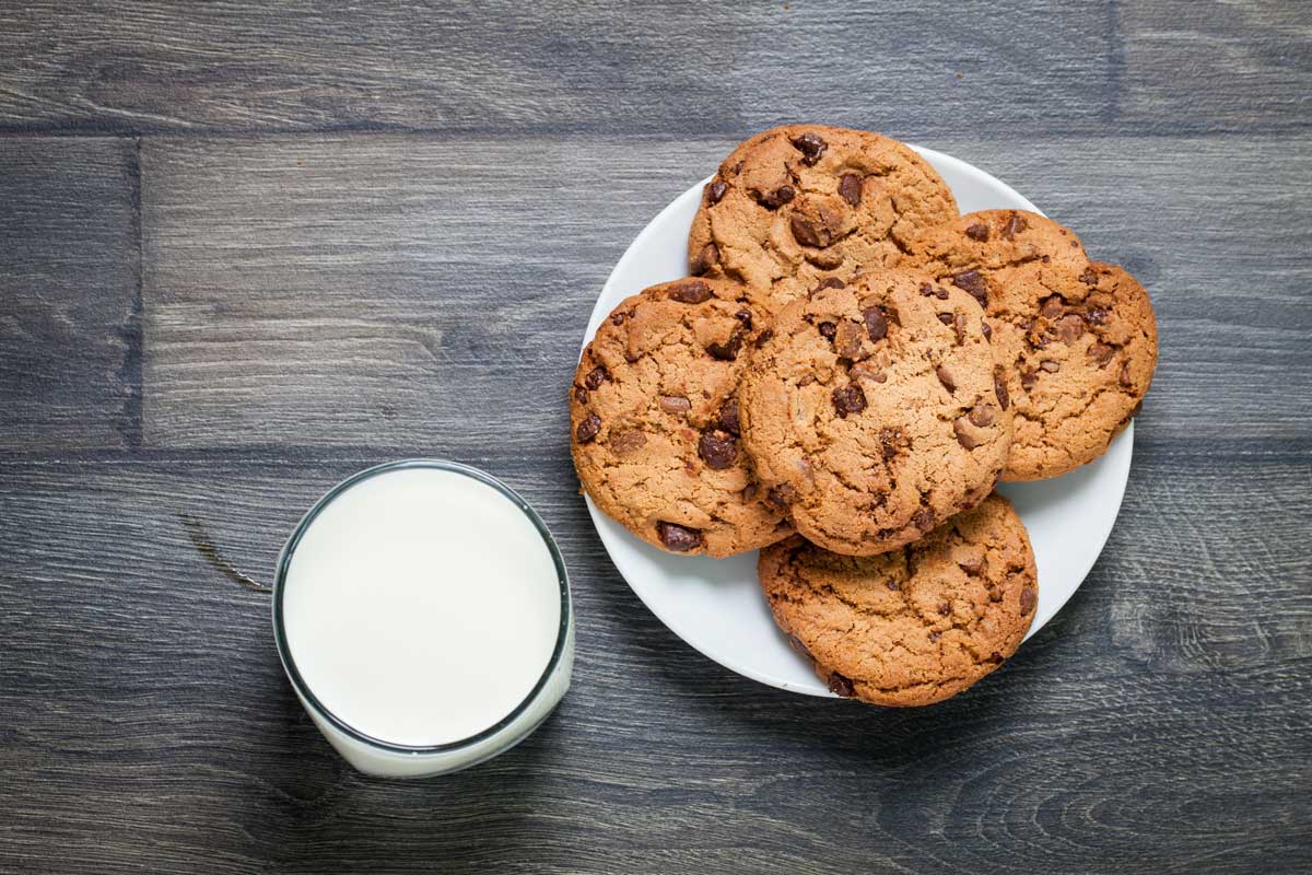 cookies on a plate with a glass of milk